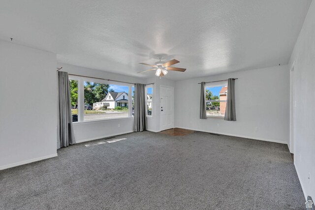 363 E Factory St, Garland, UT 84312 - empty room with ceiling fan, dark colored carpet, and a textured ceiling