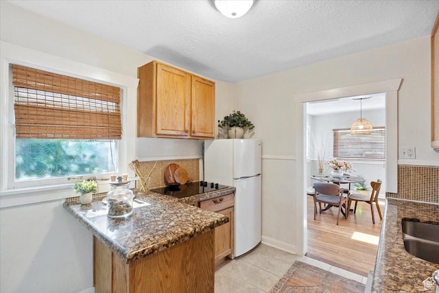 851 E Elm Ave, Salt Lake City, UT 84106 - kitchen featuring freestanding refrigerator, healthy amount of natural light, light tile patterned flooring, black electric stovetop, and a textured ceiling