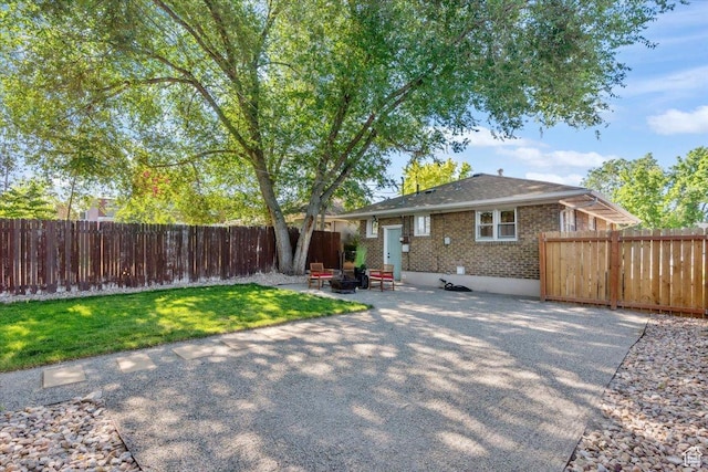 851 E Elm Ave, Salt Lake City, UT 84106 - view of front of property featuring a fenced backyard, a patio, brick siding, and an outdoor fire pit