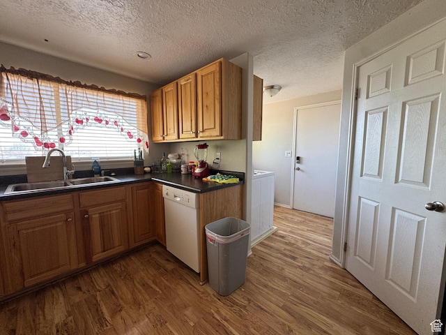 631 W Main St W, Wellington, UT 84542 - kitchen featuring white dishwasher, wood finished floors, dark countertops, washing machine and clothes dryer, and a textured ceiling