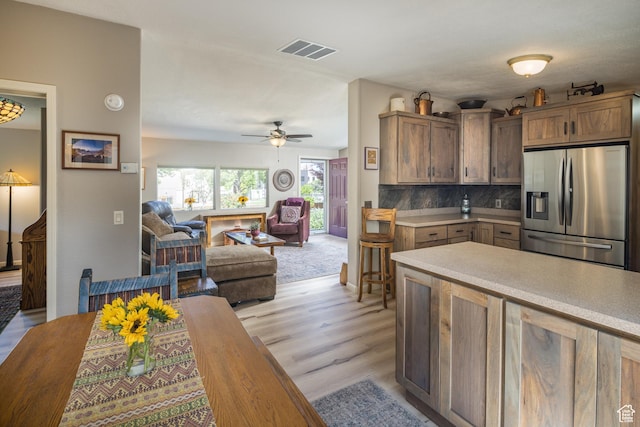 460 E Bowen Cir, Moab, UT 84532 - kitchen with stainless steel fridge with ice dispenser, light countertops, light wood-style floors, ceiling fan, and open floor plan