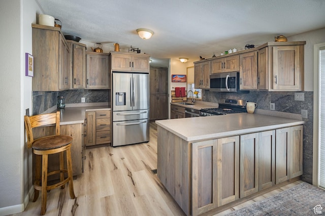 460 E Bowen Cir, Moab, UT 84532 - kitchen with stainless steel appliances, a peninsula, backsplash, and light countertops