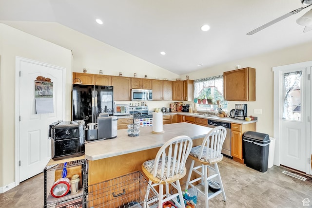 1047 W Ascot Dr N, North Salt Lake, UT 84054 - kitchen with appliances with stainless steel finishes, lofted ceiling, light countertops, ceiling fan, and a center island
