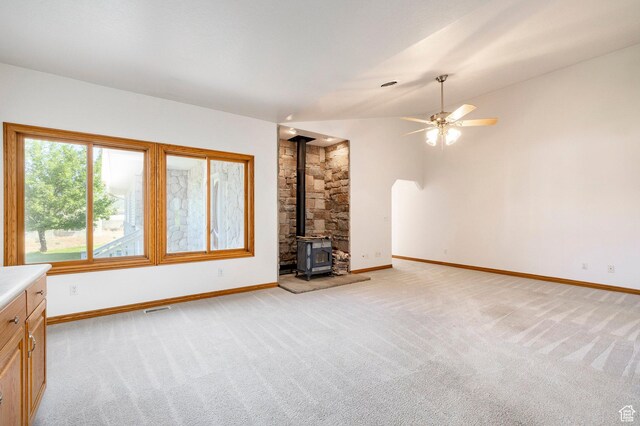 3787 E 1200 S, Heber City, UT 84032 - unfurnished living room featuring light colored carpet, a wood stove, a ceiling fan, and vaulted ceiling