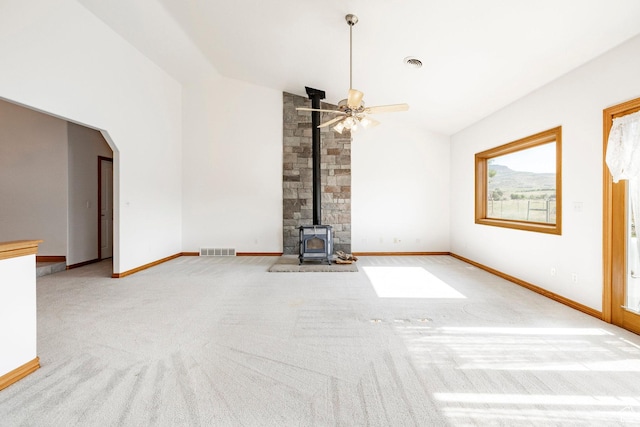 3787 E 1200 S, Heber City, UT 84032 - unfurnished living room featuring a wood stove, carpet, ceiling fan, arched walkways, and high vaulted ceiling