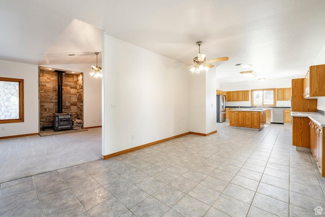 3787 E 1200 S, Heber City, UT 84032 - unfurnished living room with ceiling fan, a wood stove, light tile patterned floors, and light colored carpet