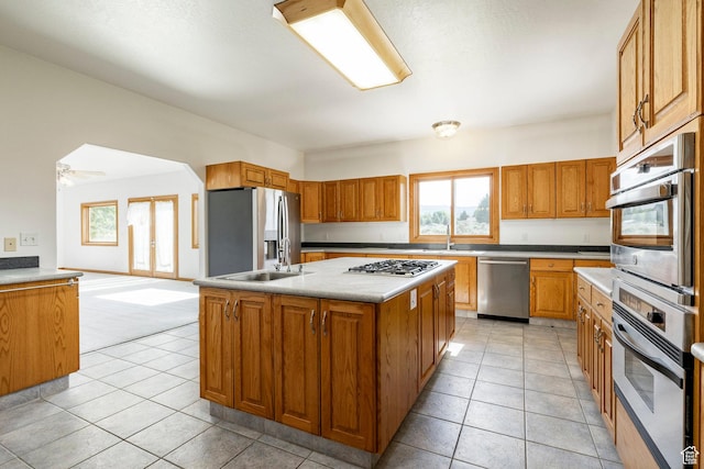 3787 E 1200 S, Heber City, UT 84032 - kitchen with stainless steel appliances, brown cabinets, a kitchen island, light tile patterned flooring, and light countertops