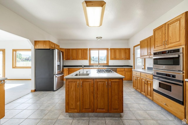 3787 E 1200 S, Heber City, UT 84032 - kitchen with stainless steel appliances, an island with sink, brown cabinets, light tile patterned floors, and light countertops