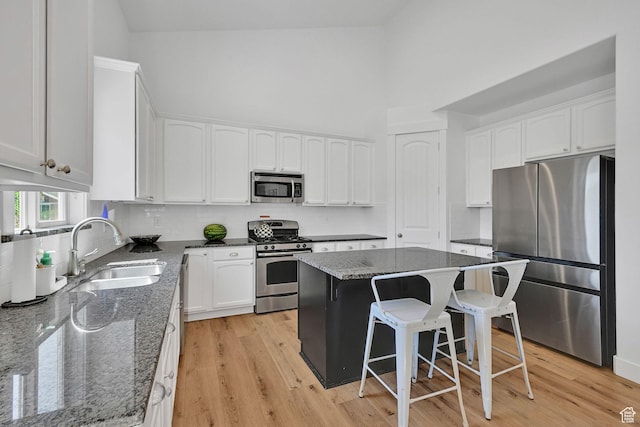 874 W Steeple Chase Dr, Kaysville, UT 84037 - kitchen with stainless steel appliances, white cabinetry, dark stone counters, a towering ceiling, and decorative backsplash