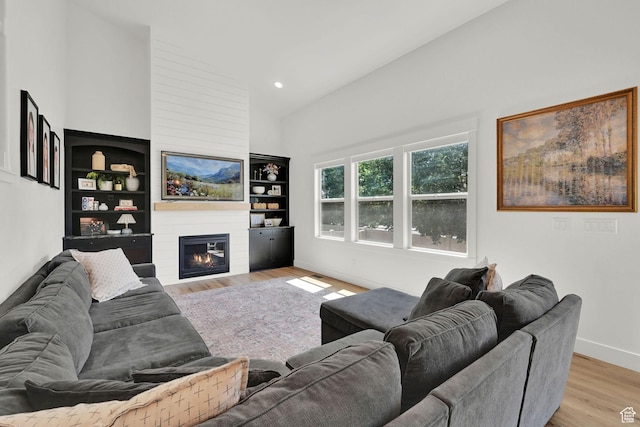874 W Steeple Chase Dr, Kaysville, UT 84037 - living room with wood finished floors, a large fireplace, high vaulted ceiling, built in shelves, and recessed lighting