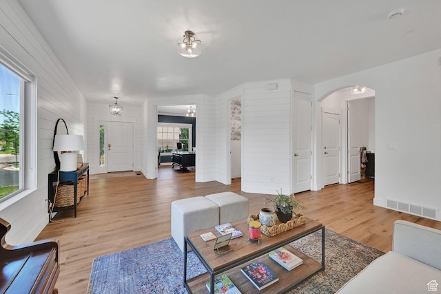 874 W Steeple Chase Dr, Kaysville, UT 84037 - living room with arched walkways, light wood finished floors, and a chandelier