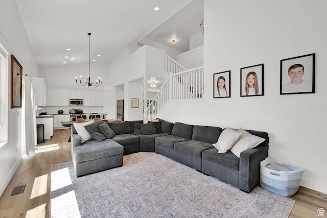 874 W Steeple Chase Dr, Kaysville, UT 84037 - living area featuring light wood-style flooring, stairway, a chandelier, high vaulted ceiling, and recessed lighting