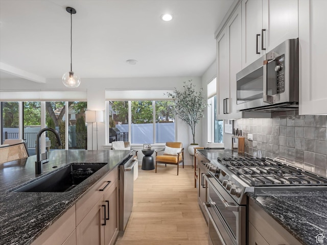 1783 E Bermondsey Ct, Holladay, UT 84117 - kitchen with appliances with stainless steel finishes, light wood finished floors, decorative backsplash, recessed lighting, and dark stone countertops