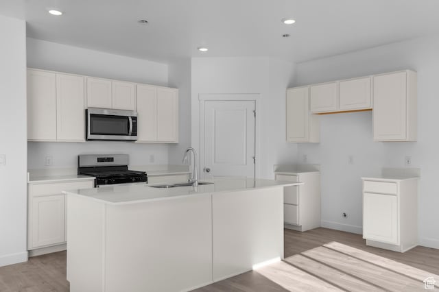 837 N 1860 E Unit 158, Salem, UT 84653 - kitchen with electric range, stainless steel microwave, light wood-style flooring, a center island with sink, and white cabinets