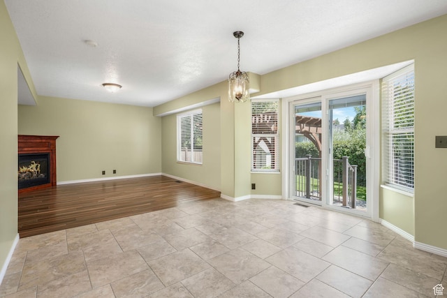 823 Creek Ln, Farmington, UT 84025 - unfurnished dining area featuring plenty of natural light, a warm lit fireplace, and a chandelier