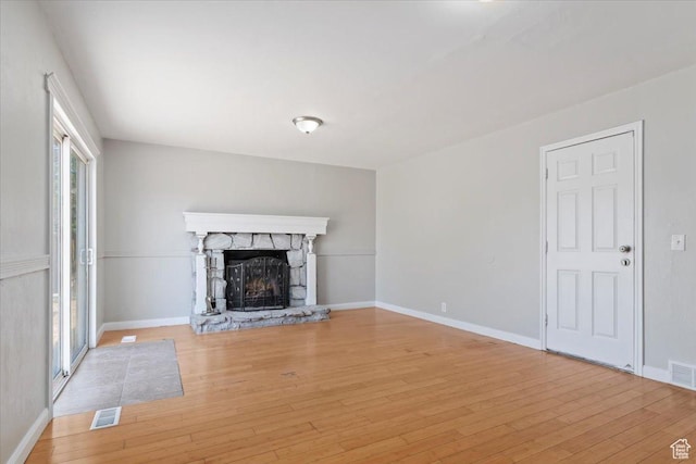 3221 W 6920 S, West Jordan, UT 84084 - unfurnished living room with light wood-type flooring, a fireplace, and healthy amount of natural light