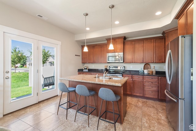 7873 S Farm House Ln E, Midvale, UT 84047 - kitchen featuring stainless steel appliances, healthy amount of natural light, brown cabinetry, an island with sink, and recessed lighting
