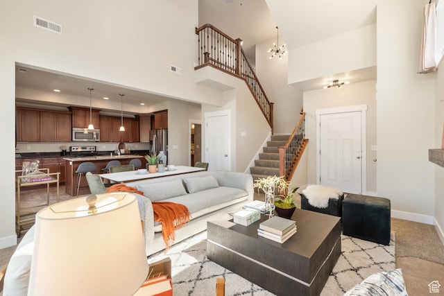 7873 S Farm House Ln E, Midvale, UT 84047 - living area with stairway, a high ceiling, light colored carpet, and a chandelier