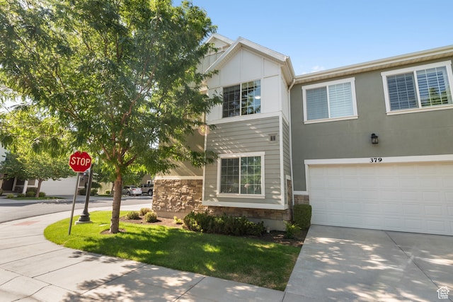7873 S Farm House Ln E, Midvale, UT 84047 - view of property featuring stone siding, concrete driveway, a garage, and a front yard