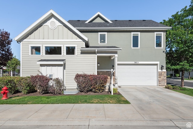 7873 S Farm House Ln E, Midvale, UT 84047 - view of front of property featuring board and batten siding, stone siding, driveway, an attached garage, and a shingled roof
