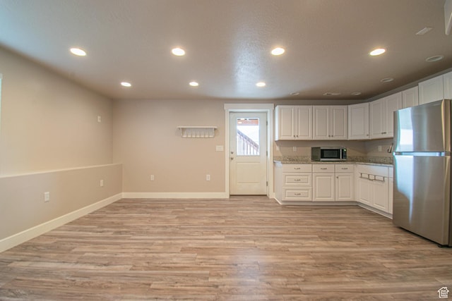 1233 E Upland Dr S Unit 112, Tooele, UT 84074 - kitchen with appliances with stainless steel finishes, recessed lighting, light wood finished floors, and white cabinets