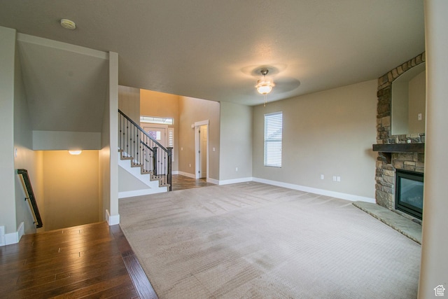 1233 E Upland Dr S Unit 112, Tooele, UT 84074 - unfurnished living room featuring ceiling fan, a stone fireplace, stairs, and wood finished floors
