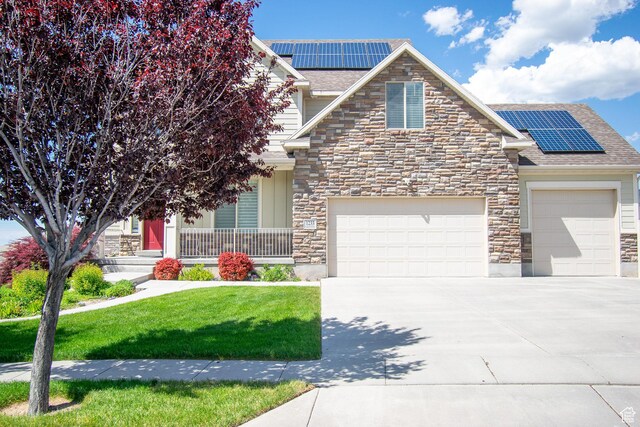 1233 E Upland Dr S Unit 112, Tooele, UT 84074 - view of front of house featuring stone siding, roof mounted solar panels, and a garage