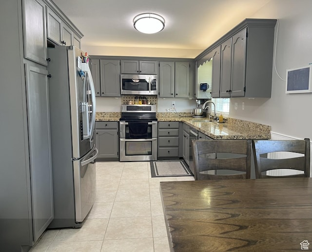 663 E 485 S, Orem, UT 84097 - kitchen featuring stainless steel appliances, gray cabinets, light stone counters, and light tile patterned floors