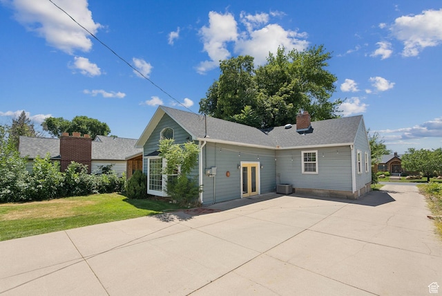 145 S 300 E, Kaysville, UT 84037 - view of front of house with a front lawn, a chimney, driveway, a patio area, and roof with shingles
