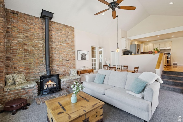 145 S 300 E, Kaysville, UT 84037 - living room featuring a wood stove, dark colored carpet, a ceiling fan, and high vaulted ceiling