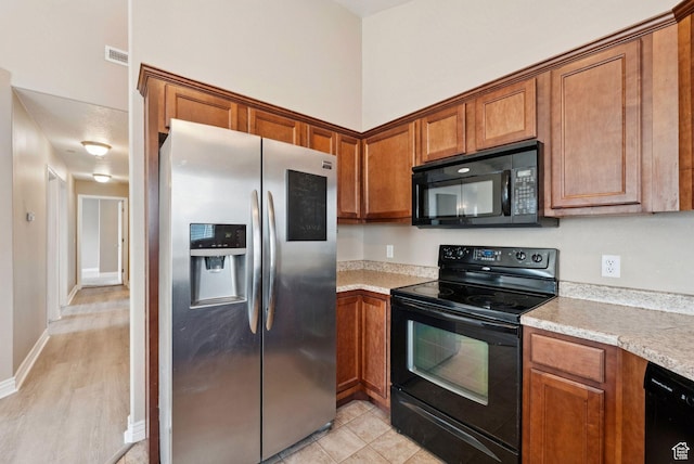 8229 S Resaca Dr Unit D11, Sandy, UT 84070 - kitchen with black appliances, brown cabinetry, and light wood-style floors