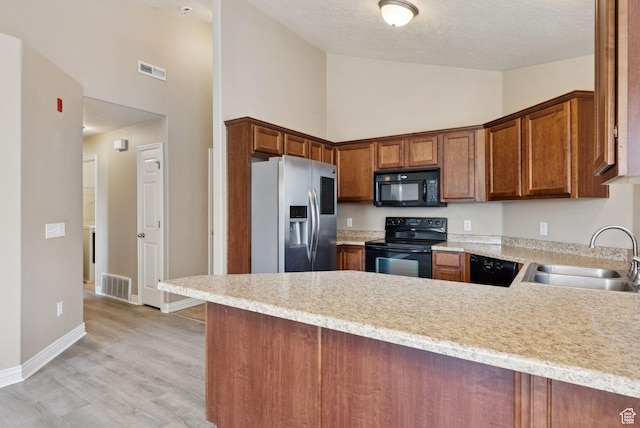 8229 S Resaca Dr Unit D11, Sandy, UT 84070 - kitchen with black appliances, high vaulted ceiling, light countertops, a peninsula, and a textured ceiling