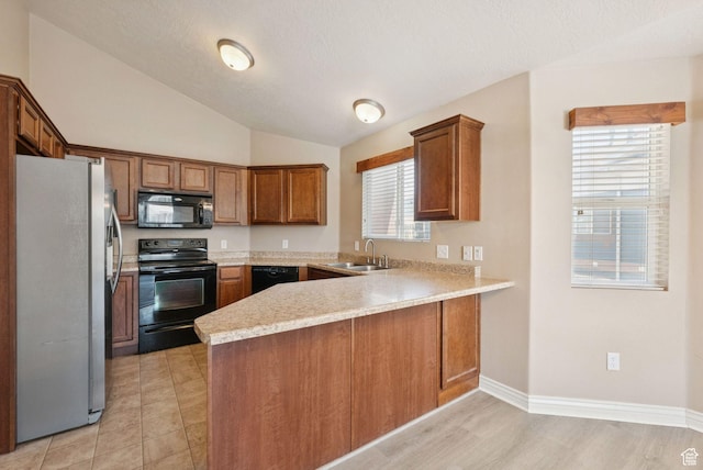 8229 S Resaca Dr Unit D11, Sandy, UT 84070 - kitchen with black appliances, a peninsula, light countertops, vaulted ceiling, and brown cabinets