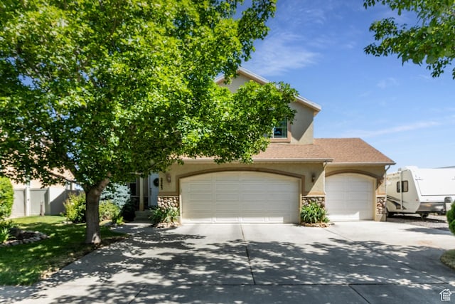 2343 E 1580 S, Spanish Fork, UT 84660 - obstructed view of property featuring stucco siding, stone siding, driveway, and an attached garage