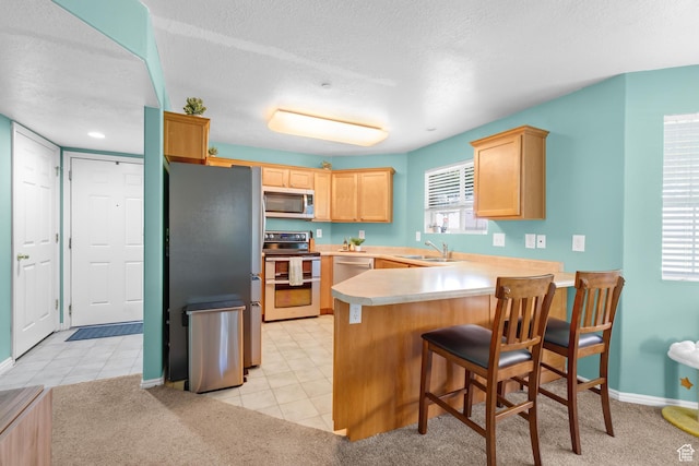 2103 N Aurora Way, Saratoga Springs, UT 84045 - kitchen featuring stainless steel appliances, light brown cabinetry, a peninsula, light countertops, and light tile patterned flooring