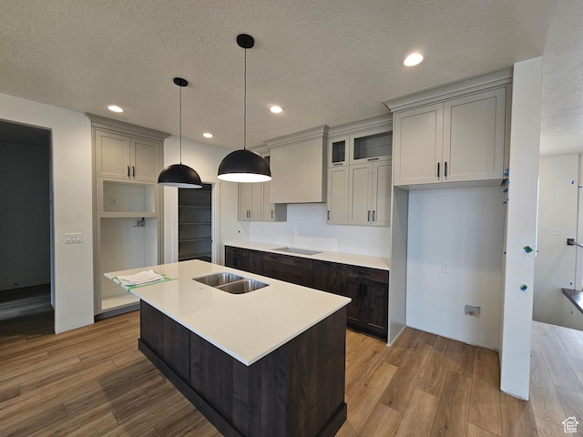 1768 S 3875 W Unit 227, Taylor, UT 84401 - kitchen featuring black electric stovetop, light wood-style flooring, a kitchen island with sink, a textured ceiling, and recessed lighting