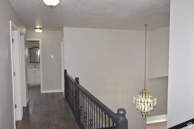 107 W High Sierra Dr, Elk Ridge, UT 84651 - hallway featuring an upstairs landing, a textured ceiling, a chandelier, and dark wood-style flooring
