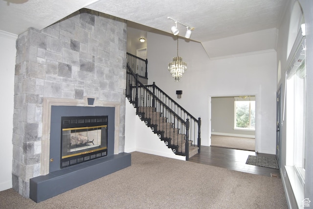 107 W High Sierra Dr, Elk Ridge, UT 84651 - entryway with carpet floors, stairs, a textured ceiling, a glass covered fireplace, and a chandelier