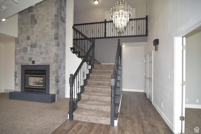 107 W High Sierra Dr, Elk Ridge, UT 84651 - stairs with wood finished floors, a chandelier, a glass covered fireplace, and a high ceiling