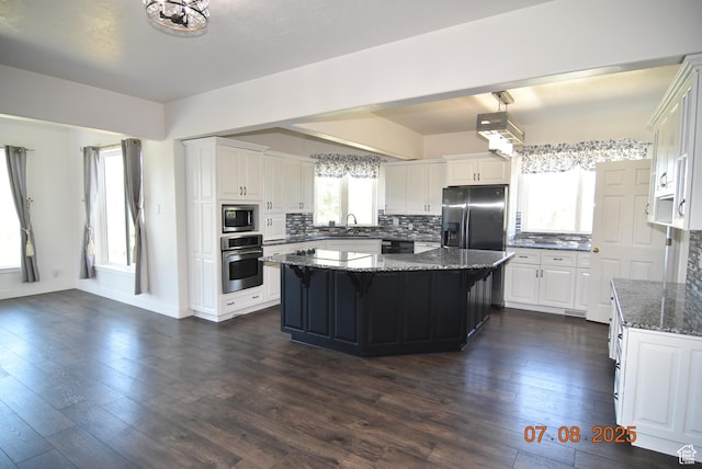 107 W High Sierra Dr, Elk Ridge, UT 84651 - kitchen with appliances with stainless steel finishes, a kitchen island, tasteful backsplash, and white cabinets
