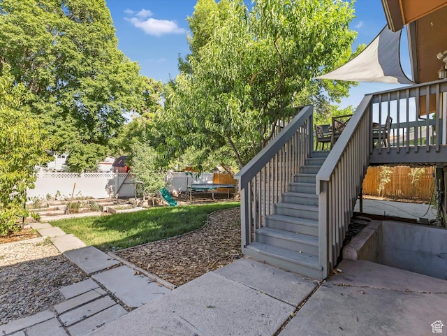 9457 S Poppy Ln, Sandy, UT 84094 - view of yard featuring a trampoline, stairs, and a deck