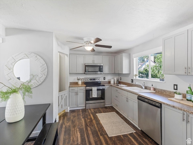 9457 S Poppy Ln, Sandy, UT 84094 - kitchen featuring appliances with stainless steel finishes, dark wood finished floors, a ceiling fan, light countertops, and backsplash