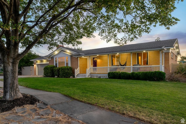 3558 S Chippewa Rd, West Valley City, UT 84120 - single story home featuring brick siding, covered porch, a garage, a front lawn, and concrete driveway