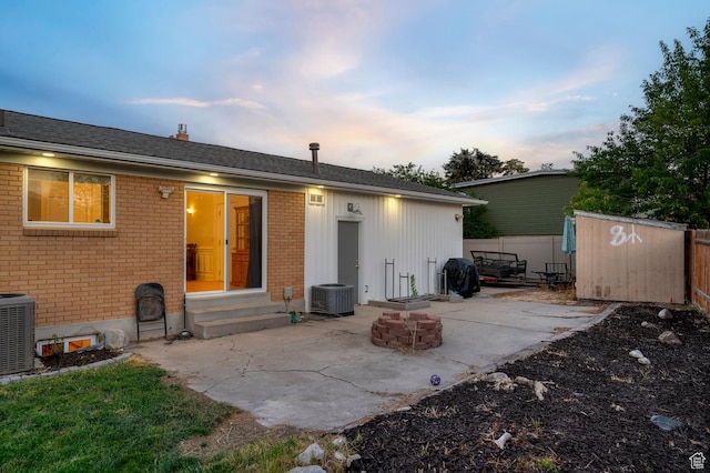 3558 S Chippewa Rd, West Valley City, UT 84120 - back of property featuring entry steps, a patio area, brick siding, an outdoor fire pit, and a storage unit