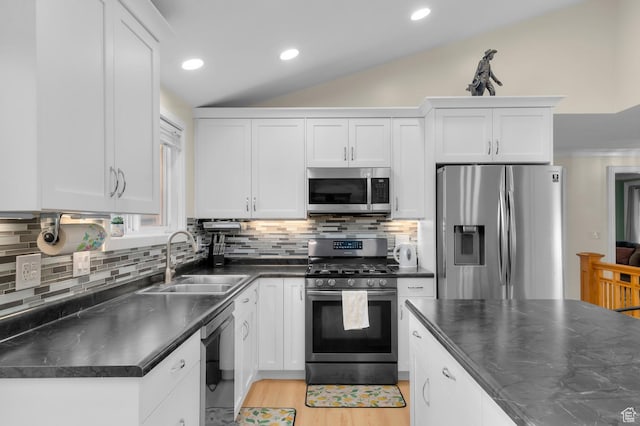 3558 S Chippewa Rd, West Valley City, UT 84120 - kitchen with stainless steel appliances, dark countertops, lofted ceiling, white cabinets, and tasteful backsplash