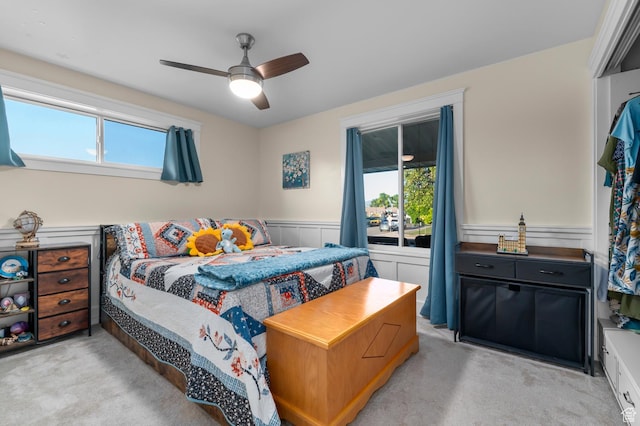 3558 S Chippewa Rd, West Valley City, UT 84120 - bedroom featuring light colored carpet, multiple windows, wainscoting, and ceiling fan