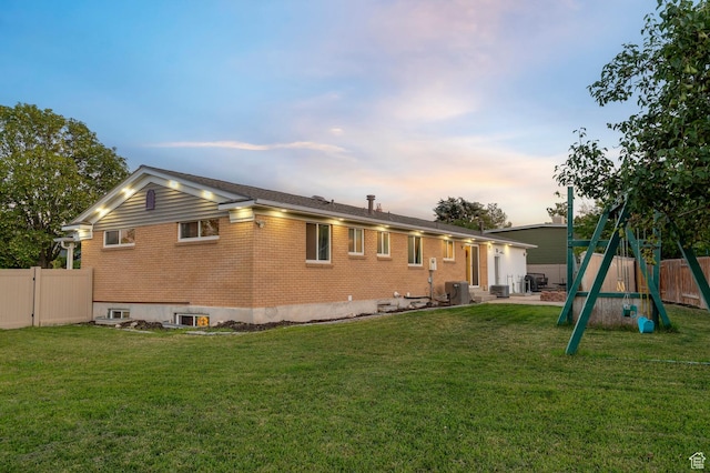 3558 S Chippewa Rd, West Valley City, UT 84120 - back of house at dusk with brick siding, a playground, and entry steps