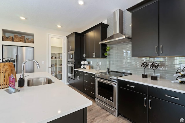 6181 W Franciscotti Dr Unit 521, South Jordan, UT 84009 - kitchen featuring appliances with stainless steel finishes, wall chimney exhaust hood, dark cabinetry, light countertops, and recessed lighting