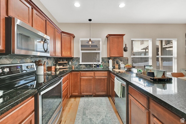 861 E Red Sage Ln, Murray, UT 84107 - kitchen featuring appliances with stainless steel finishes, light wood-type flooring, tasteful backsplash, brown cabinetry, and dark stone counters
