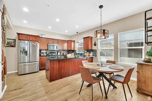 861 E Red Sage Ln, Murray, UT 84107 - kitchen featuring appliances with stainless steel finishes, light wood-style floors, decorative backsplash, brown cabinets, and pendant lighting